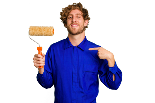Young painter man holding a roll isolated on white background person pointing by hand to a shirt copy space, proud and confident