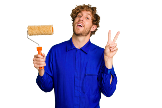 Young painter man holding a roll isolated on white background joyful and carefree showing a peace symbol with fingers.