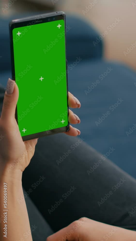 Aufkleber vertical video: freelancer holding in vertical mode smartphone with mock up green screen chroma key 