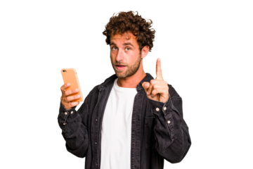 Young caucasian man using mobile phone isolated having an idea, inspiration concept.