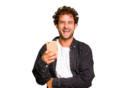 Young caucasian man using mobile phone isolated laughing and having fun.
