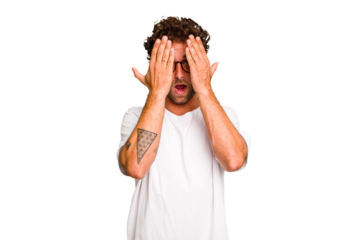 Young caucasian curly hair man isolated Young caucasian man with curly hair isolated having fun covering half of face with palm.