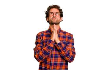 Young caucasian curly hair man isolated Young caucasian man with curly hair isolated holding hands in pray near mouth, feels confident.