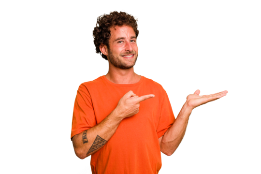 Young caucasian curly hair man isolated Young caucasian man with curly hair isolated excited holding a copy space on palm.