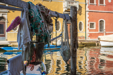 Colorful boats and fishing nets along the canal - Chioggia city, Venice Lagoon, Verona province, Italy