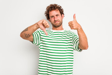 Young caucasian curly hair man isolated on white background showing thumbs up and thumbs down, difficult choose concept
