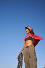Portrait of young non-binary standing with skateboard smiling  © Sheilby Macena