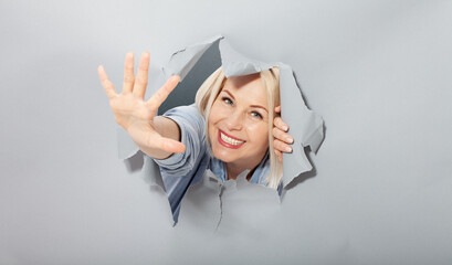 Attractive joyful middle aged woman waving a greeting gesture with her hand, shows that everything...
