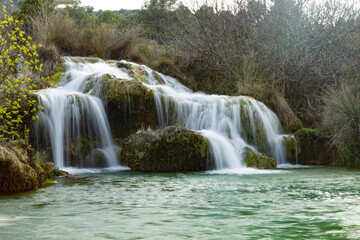 waterfall in lagoons with green water on stones