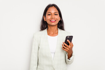 Fototapeta premium Young business Indian woman holding a mobile phone isolated on white background happy, smiling and cheerful.
