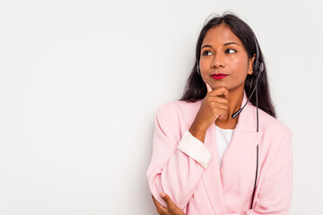 Telemarketer Indian woman working with a headset isolated on white background looking sideways with doubtful and skeptical expression.