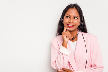 Telemarketer Indian woman working with a headset isolated on white background relaxed thinking...