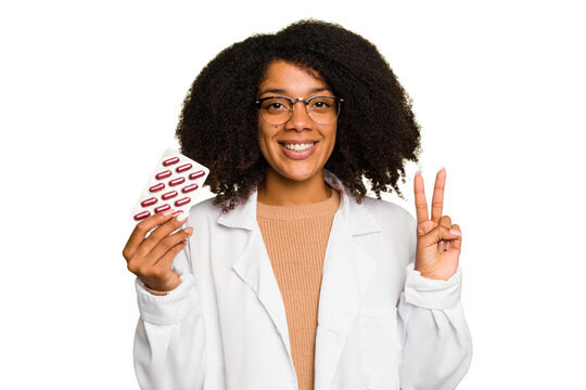 Young pharmacist African American woman holding a tablet of pills isolated showing number two with fingers.