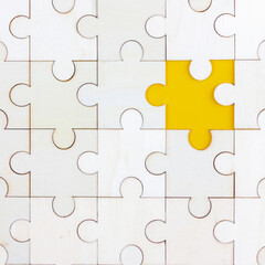 Fototapeta premium White Wood jigsaw puzzle on yellow background with copy space. Business strategy teamwork or problem solving concept.