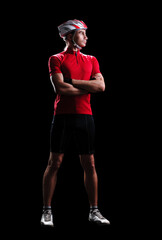 Full length portrait of a mountain biker with crossed hands in a black studio