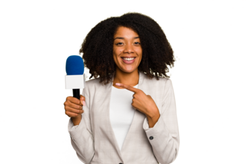 Young TV presenter African American woman with a microphone isolated smiling and pointing aside, showing something at blank space.