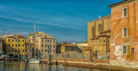 Chioggia cityscape with narrow water canal with moored boats, buildings - Venetian lagoon, Venice province, Italy - October 30, 2021