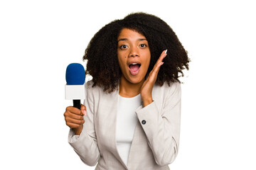 Young TV presenter African American woman with a microphone isolated surprised and shocked. - obrazy, fototapety, plakaty