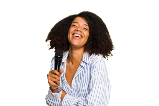 Young African American singer woman holding a microphone isolated laughing and having fun.