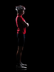 Profile full length low key silhouette portrait of a cyclist with crossed hands