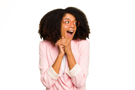 Young African American woman isolated keeps hands under chin, is looking happily aside.