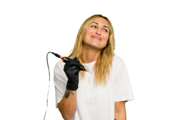 Tattoo artist caucasian woman isolated on green chroma background dreaming of achieving goals and purposes