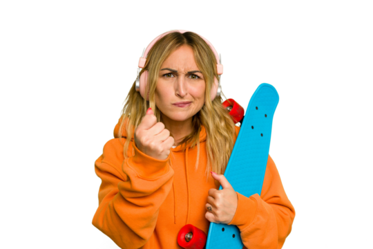 Young caucasian skater woman isolated on green chroma background showing fist to camera, aggressive facial expression.