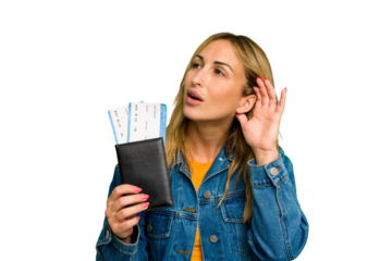 Young caucasian woman holding a passport isolated on green chroma background trying to listening a gossip.