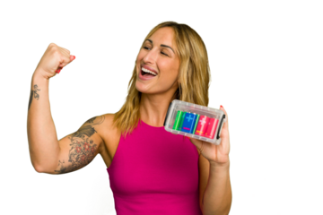 Young caucasian woman holding battery box isolated on green chroma background raising fist after a victory, winner concept.