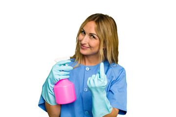 Young cleaner caucasian woman isolated green chroma background pointing with finger at you as if inviting come closer.