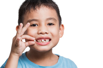 close up boy kid with opened mouth pointing at missing front baby tooth with finger smiling excitedly in on white background