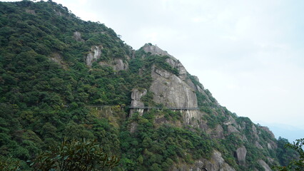 Fototapeta na wymiar The beautiful mountains landscapes with the green forest and a plank road built along the face of a cliff in the countryside of the China