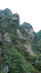 The beautiful mountains landscapes with the green forest and a plank road built along the face of a cliff in the countryside of the China