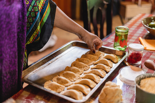 Imagen horizontal de una mujer afrocaribe&ntilde;a irreconocible preparando unas deliciosas empanadas en su casa. 