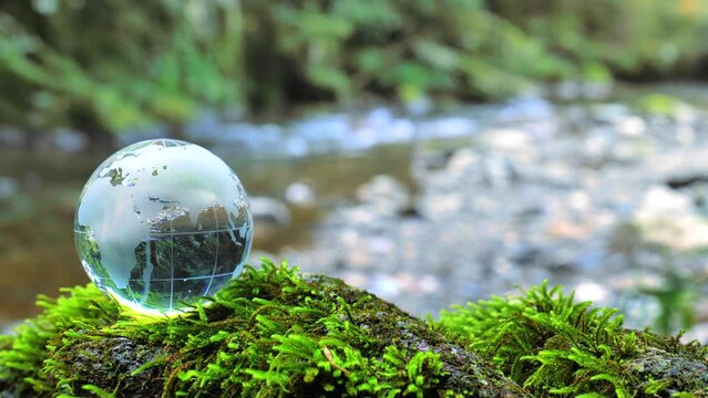 中東を中心としたクリスタルの地球儀の背景に清流が流れている