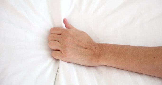 Female hand squeezing white sheet during orgasm closeup 4k movie slow motion