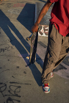 Portrait Of Young Non-binary Waist Down With Skateboard
