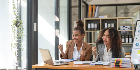 Two young Asian business woman talk, consult, discuss working with new startup project idea presentation analyze plan marketing and investment in the office.