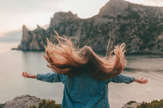 Young Woman With Long Blond Hair Enjoys The Mountain Scenery