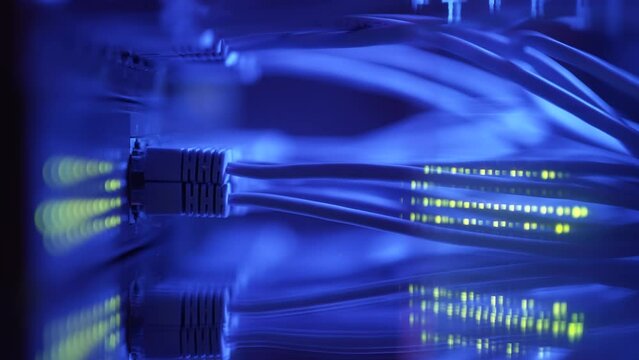 Close-up view of modern internet network switch with plugged ethernet cables. Blinking lights on internet server. Concept of data center. Cloud computing and telecommunications