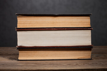 An old book on a wooden table and on a dark background