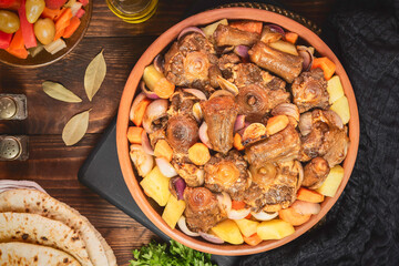 Arabic Cuisine; Egyptian traditional oxtails stew with vegetables. Served with traditional flatbread and pickles. - obrazy, fototapety, plakaty