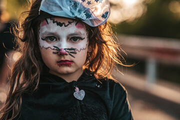 little girl dressed as black cats celebrating a Halloween party