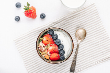 Oat muesli with yogurt and fresh berries in a bowl for a healthy breakfast top view