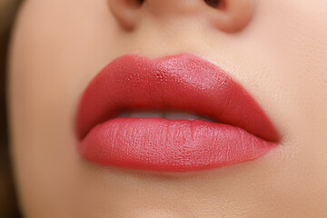 lips close-up made with permanent lip makeup with a delicate red pigment - obrazy, fototapety, plakaty