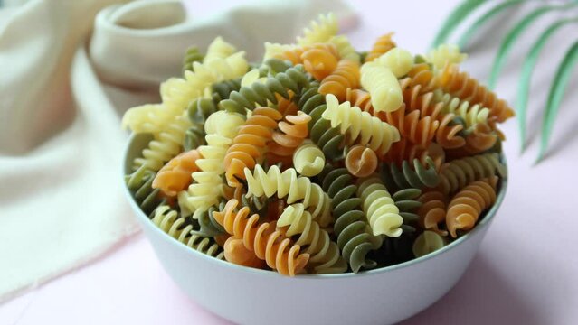 Organic fusilli tricolore in a bowl background 