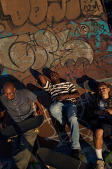 Obraz na płótnie Canvas Three young skateboarders in skatepark hanging out 