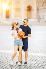 Fototapeta premium A young couple of travellers hugging in the city and enjoying romance. Lovers smiling and have fun together. tourism, travel, people, leisure and teenage concept. friendship of teenagers
