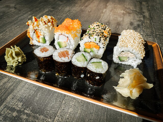 viele verschieden feine, leckere, dekorative Sushi und Sashimi Rollen auf einem Teller