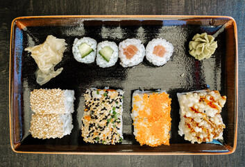 viele verschieden feine, leckere, dekorative Sushi und Sashimi Rollen auf einem Teller. Vogelperspektive